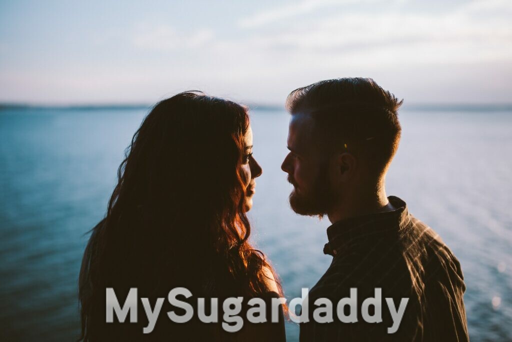 sugar daddy e sugar baby - coppia uomo donna che si fissano in riva al mare - foto romantica